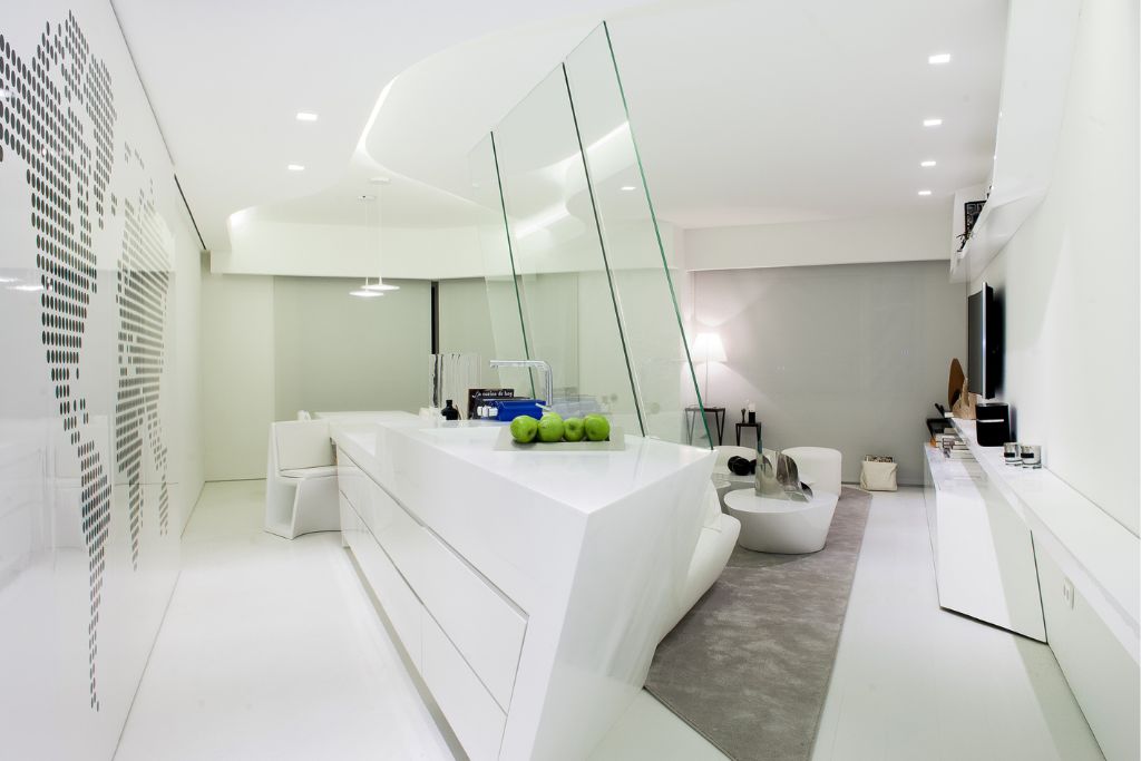 Una de las cocinas abiertas al salón diseñada por a-cero en una vivienda con interior blanco del Edificio Torre de Madrid