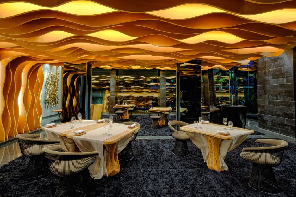 proyecto de diseño de restaurantes de A-cero en Hotel Iniala Beach House con tonos naranjas y madera con formas orgánicas que generan dinamismo.