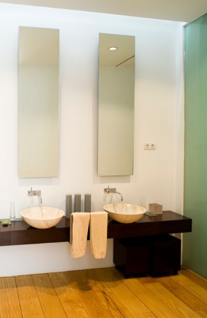 lavabos de mármol travertino en un baño de una vivienda de Madrid