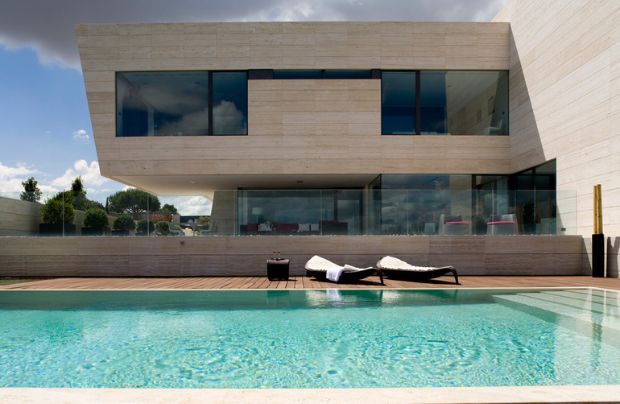 una piscina de una casa de lujo con el suelo de madera diseñada por A-cero